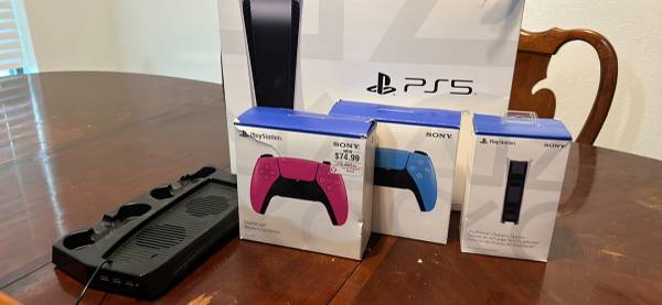 ps5 console, 3 whitebluepink controllers, console fan mount, and dual charging $500