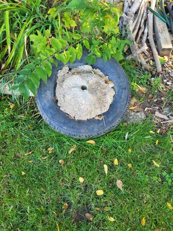 Tire filled with concrete for boat moor or volleyball post